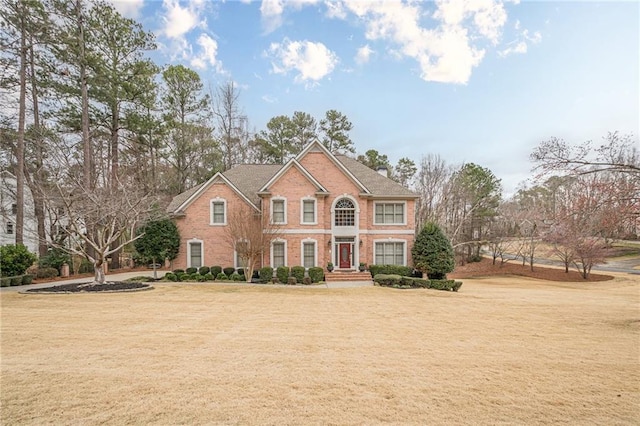 view of front of home with brick siding and a front yard