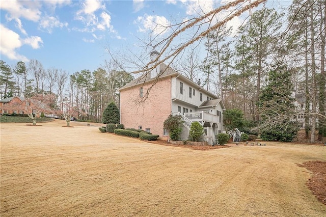 view of side of property with a lawn and stairs