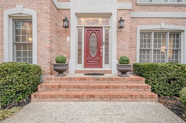 doorway to property featuring brick siding