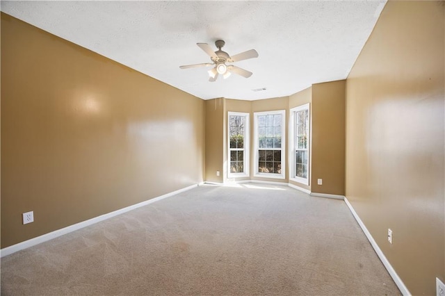 spare room featuring light colored carpet and ceiling fan