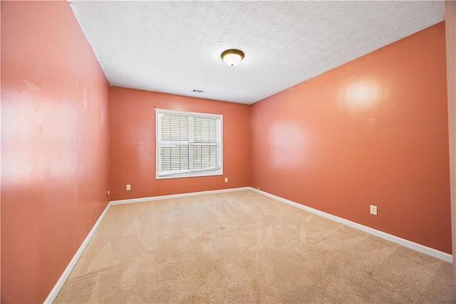 unfurnished room with carpet and a textured ceiling