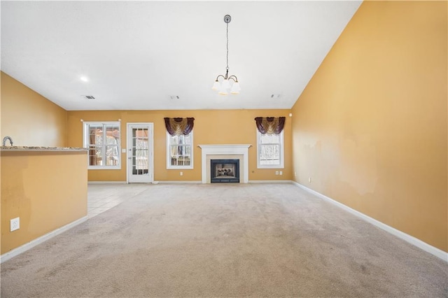 unfurnished living room with light carpet and a notable chandelier