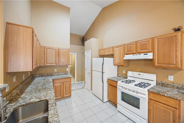 kitchen featuring white appliances, high vaulted ceiling, sink, light stone countertops, and light tile patterned floors