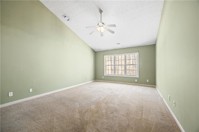 spare room featuring ceiling fan, light colored carpet, lofted ceiling, and a textured ceiling