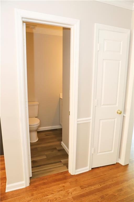 bathroom with toilet and hardwood / wood-style floors