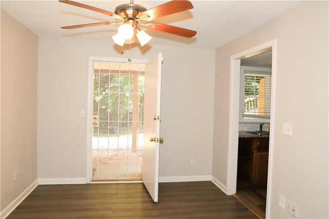 interior space with a wealth of natural light, ceiling fan, dark hardwood / wood-style floors, and sink