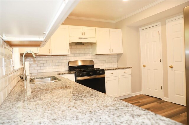 kitchen with ornamental molding, white cabinetry, range with gas stovetop, sink, and hardwood / wood-style flooring