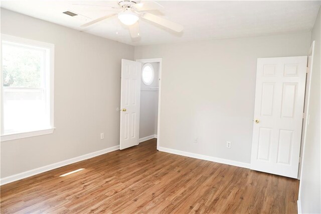 empty room with ceiling fan and light hardwood / wood-style flooring