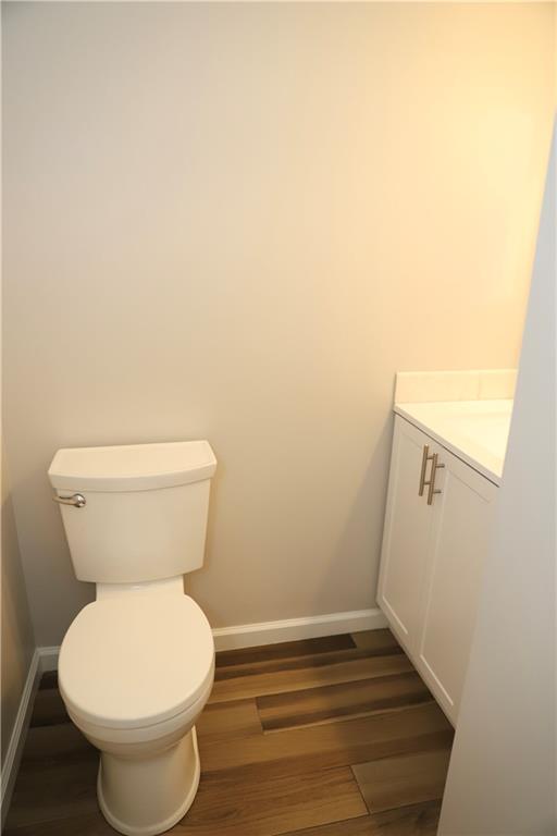 bathroom with vanity, toilet, and wood-type flooring