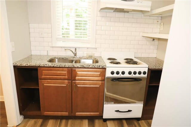 kitchen with hardwood / wood-style flooring, light stone counters, sink, electric stove, and tasteful backsplash