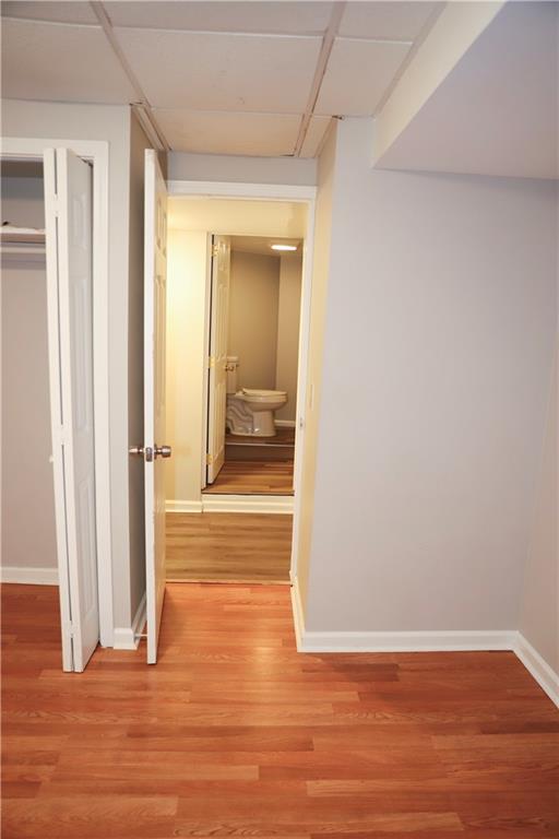 hallway featuring light hardwood / wood-style flooring and a drop ceiling