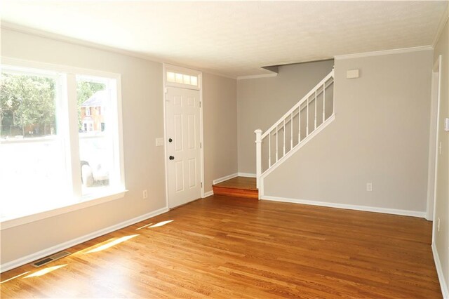 entryway with crown molding and hardwood / wood-style flooring