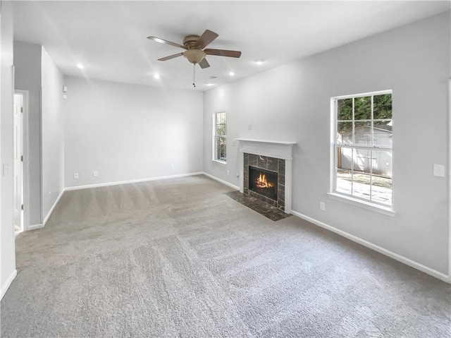 unfurnished living room with a tile fireplace, baseboards, and recessed lighting