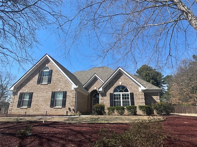 view of front of home with brick siding and fence