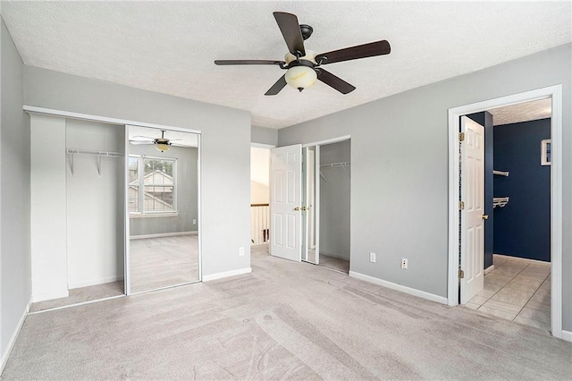 139 W Oaks Pl, Woodstock, GA 30188 - unfurnished bedroom with two closets, carpet floors, a textured ceiling, ensuite bathroom, and a ceiling fan