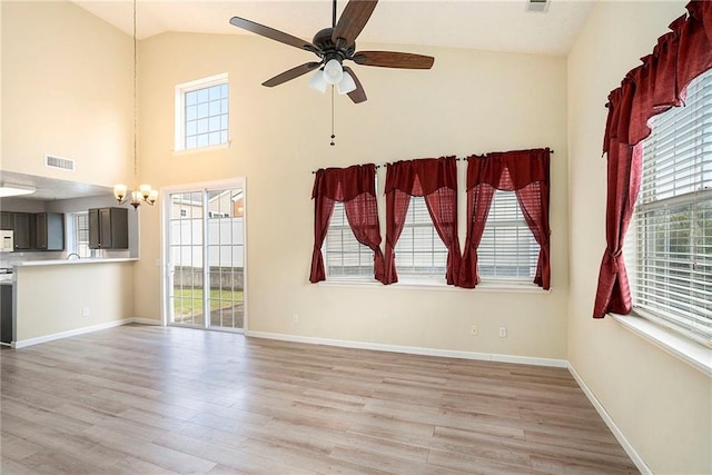 139 W Oaks Pl, Woodstock, GA 30188 - unfurnished living room featuring light wood-style floors, plenty of natural light, ceiling fan, a chandelier, and high vaulted ceiling