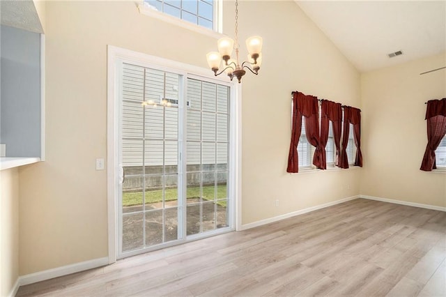139 W Oaks Pl, Woodstock, GA 30188 - unfurnished dining area featuring a chandelier, plenty of natural light, wood finished floors, and high vaulted ceiling