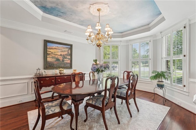 3235 Munsey Ct, Cumming, GA 30041 - dining area with a raised ceiling, a chandelier, crown molding, wood finished floors, and a wainscoted wall