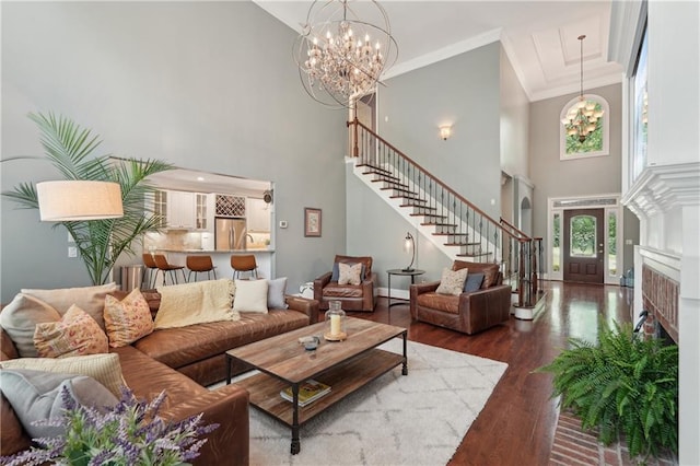 3235 Munsey Ct, Cumming, GA 30041 - living room with a towering ceiling, a chandelier, stairway, wood finished floors, and crown molding