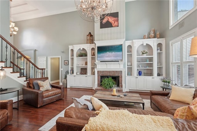 3235 Munsey Ct, Cumming, GA 30041 - living room with a towering ceiling, a chandelier, stairway, a brick fireplace, and wood finished floors
