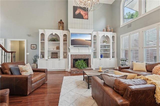 3235 Munsey Ct, Cumming, GA 30041 - living room featuring a towering ceiling, dark wood finished floors, a chandelier, and a fireplace