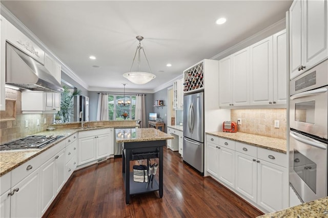 3235 Munsey Ct, Cumming, GA 30041 - kitchen with stainless steel appliances, white cabinets, crown molding, dark wood-style floors, and pendant lighting