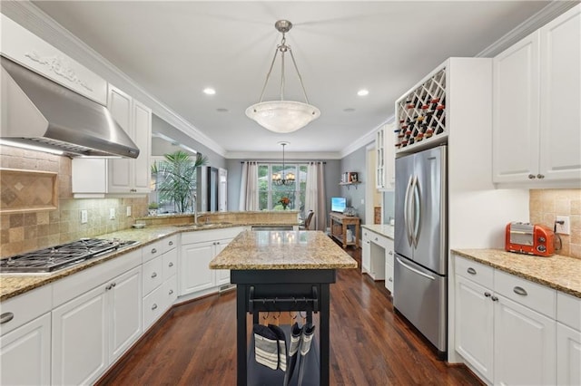 3235 Munsey Ct, Cumming, GA 30041 - kitchen with stainless steel appliances, wall chimney range hood, a peninsula, white cabinets, and ornamental molding