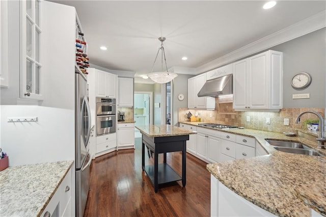 3235 Munsey Ct, Cumming, GA 30041 - kitchen with under cabinet range hood, ornamental molding, stainless steel appliances, light stone countertops, and white cabinetry