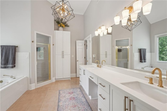 3235 Munsey Ct, Cumming, GA 30041 - bathroom featuring a chandelier, high vaulted ceiling, double vanity, a bath, and a stall shower