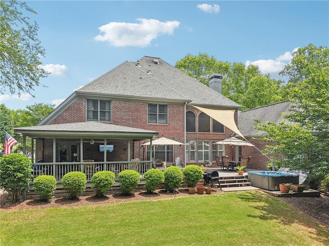 3235 Munsey Ct, Cumming, GA 30041 - back of property with a hot tub, brick siding, a yard, a chimney, and a shingled roof