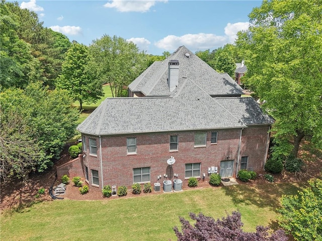 3235 Munsey Ct, Cumming, GA 30041 - back of property with a chimney, a lawn, roof with shingles, and brick siding
