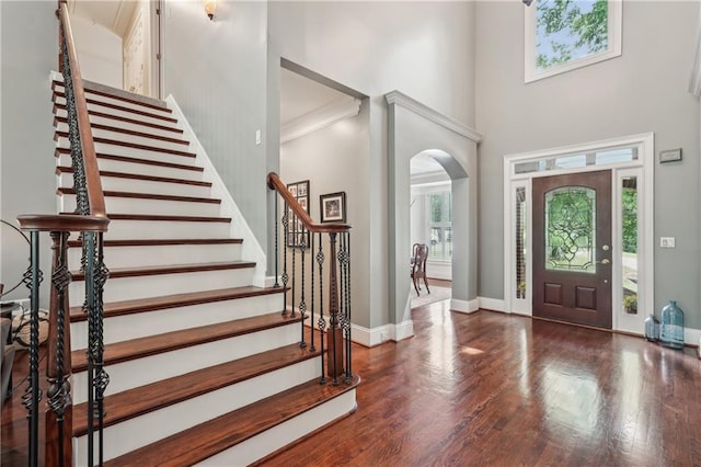 3235 Munsey Ct, Cumming, GA 30041 - entryway featuring arched walkways, a towering ceiling, stairway, and wood finished floors