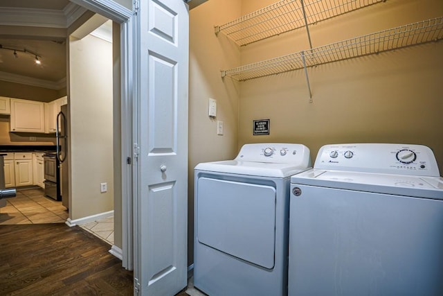 laundry room featuring laundry area, wood finished floors, washing machine and clothes dryer, crown molding, and track lighting