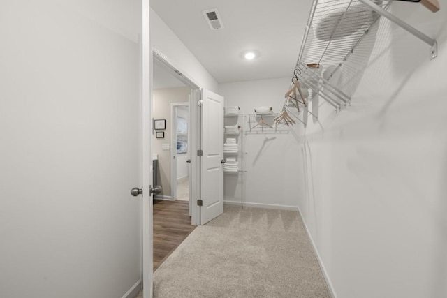 walk in closet featuring light colored carpet