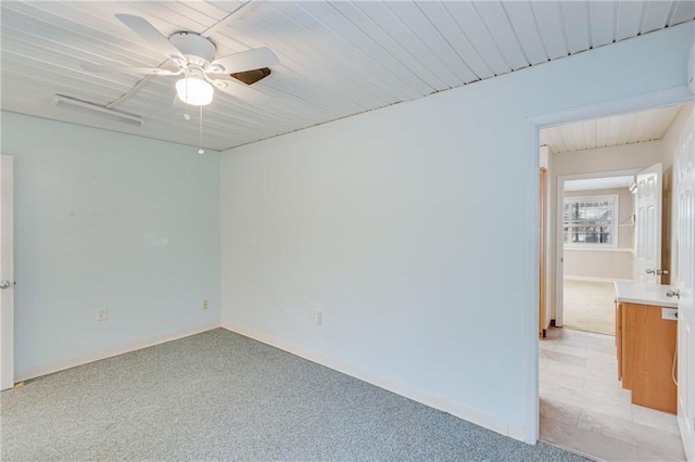 carpeted spare room featuring ceiling fan