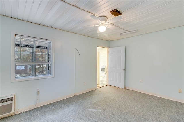 empty room featuring an AC wall unit, ceiling fan, and wooden ceiling