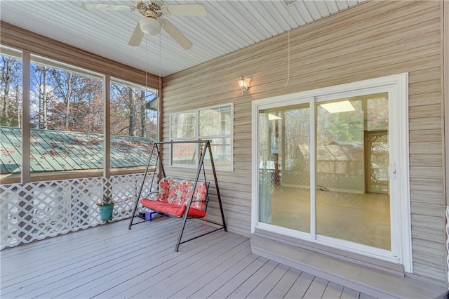 unfurnished sunroom featuring ceiling fan