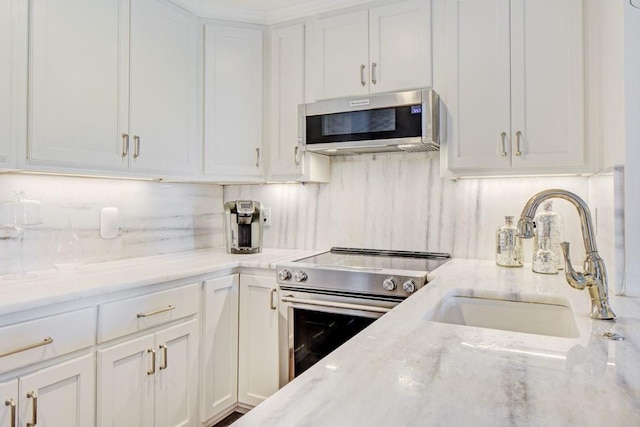 300 Johnson Ferry Rd NE Unit A706, Atlanta, GA 30328 - kitchen featuring stainless steel appliances, a sink, white cabinets, light stone counters, and tasteful backsplash