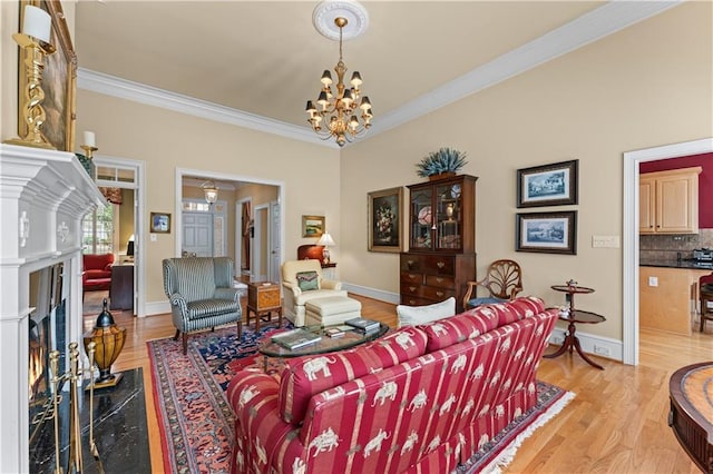 2117 Stephens Walk, Dunwoody, GA 30338 - living area featuring crown molding, light wood-type flooring, a chandelier, baseboards, and a fireplace