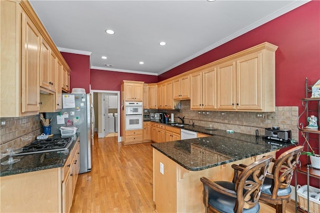 2117 Stephens Walk, Dunwoody, GA 30338 - kitchen featuring a sink, light brown cabinets, stainless steel appliances, a peninsula, and ornamental molding