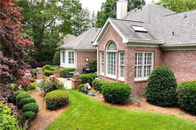 2117 Stephens Walk, Dunwoody, GA 30338 - view of property exterior with brick siding, a yard, a shingled roof, and a chimney