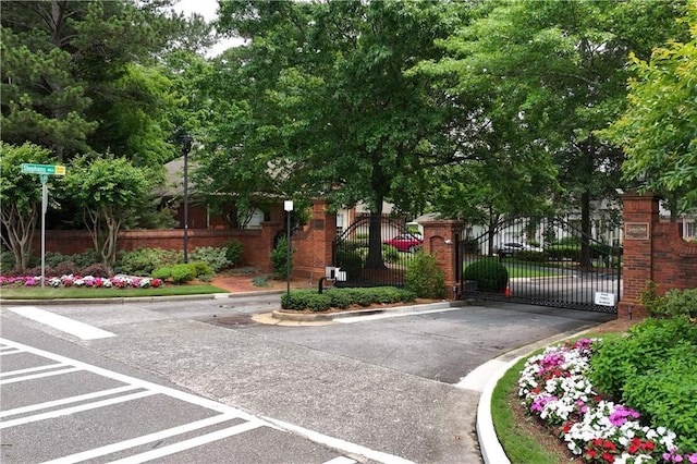 2117 Stephens Walk, Dunwoody, GA 30338 - view of asphalt road featuring street lights, curbs, a gate, and a gated entry