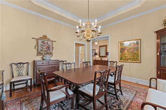 2117 Stephens Walk, Dunwoody, GA 30338 - dining area with wood finished floors, a chandelier, crown molding, a raised ceiling, and baseboards