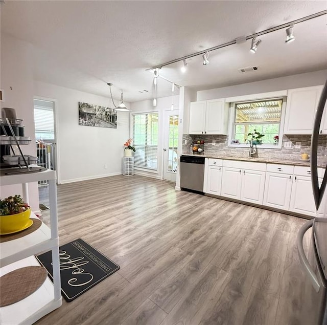 kitchen featuring tasteful backsplash, white cabinetry, dishwasher, baseboards, and light wood-style flooring