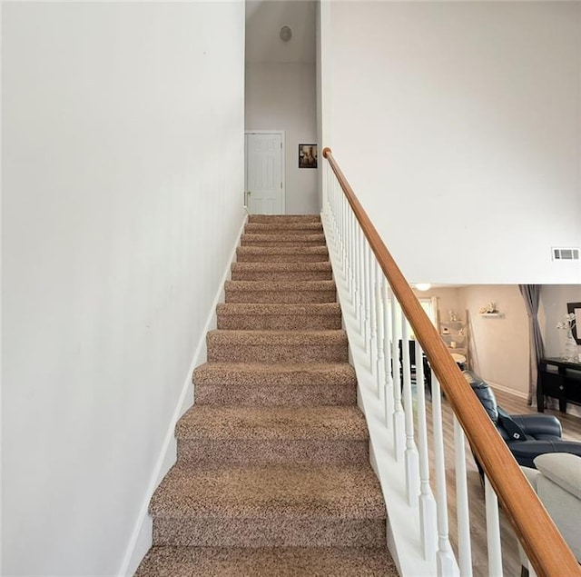 stairs with baseboards, carpet flooring, and visible vents