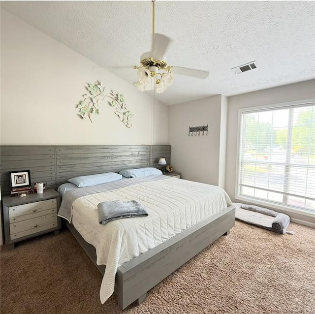 bedroom featuring carpet flooring, a textured ceiling, and visible vents