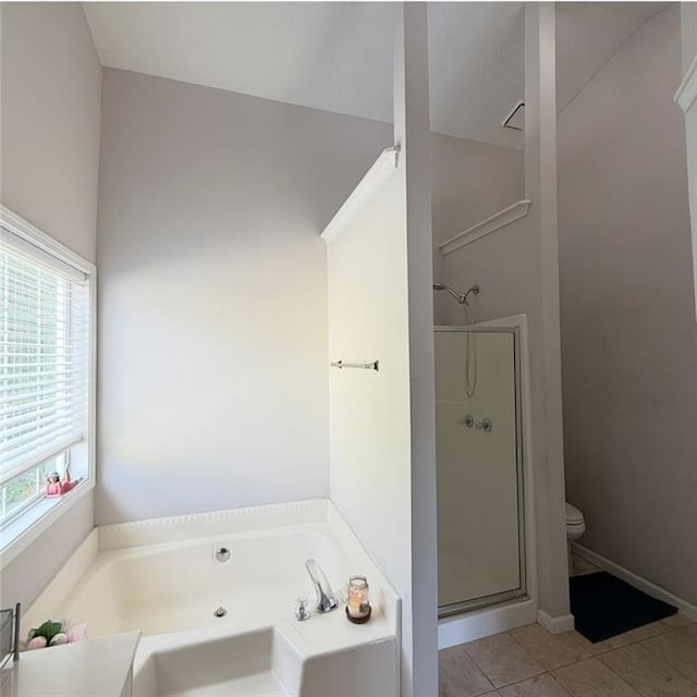 bathroom featuring tile patterned flooring, a stall shower, toilet, and a garden tub