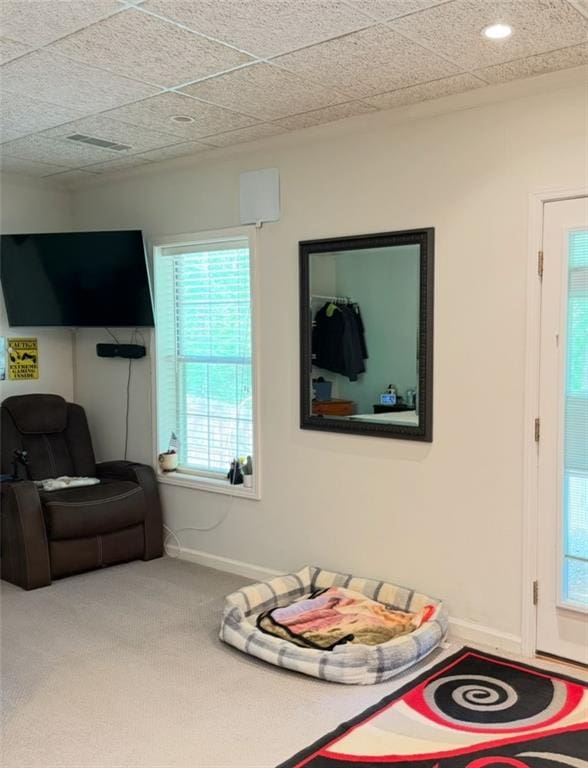 living area featuring baseboards and carpet flooring