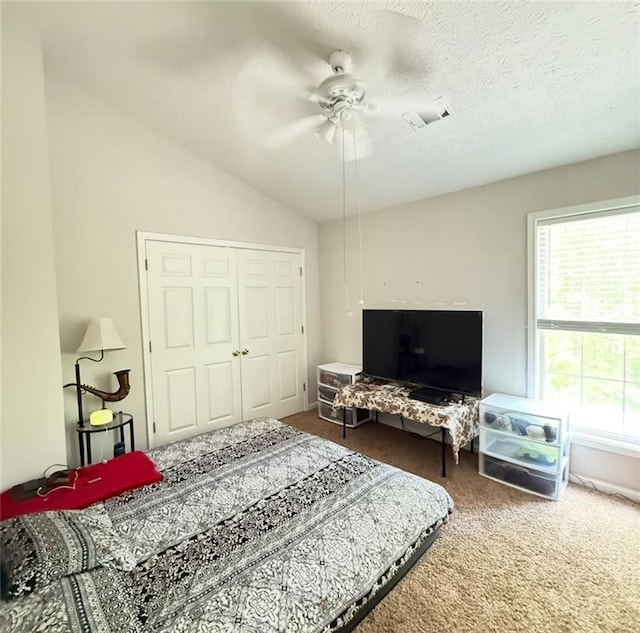 bedroom featuring ceiling fan, visible vents, carpet floors, vaulted ceiling, and a closet