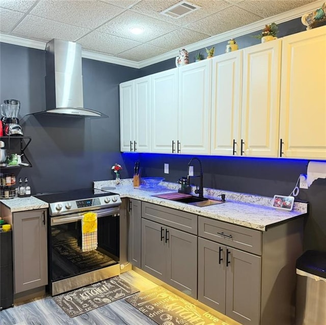 kitchen featuring wall chimney range hood, a sink, gray cabinets, and electric stove